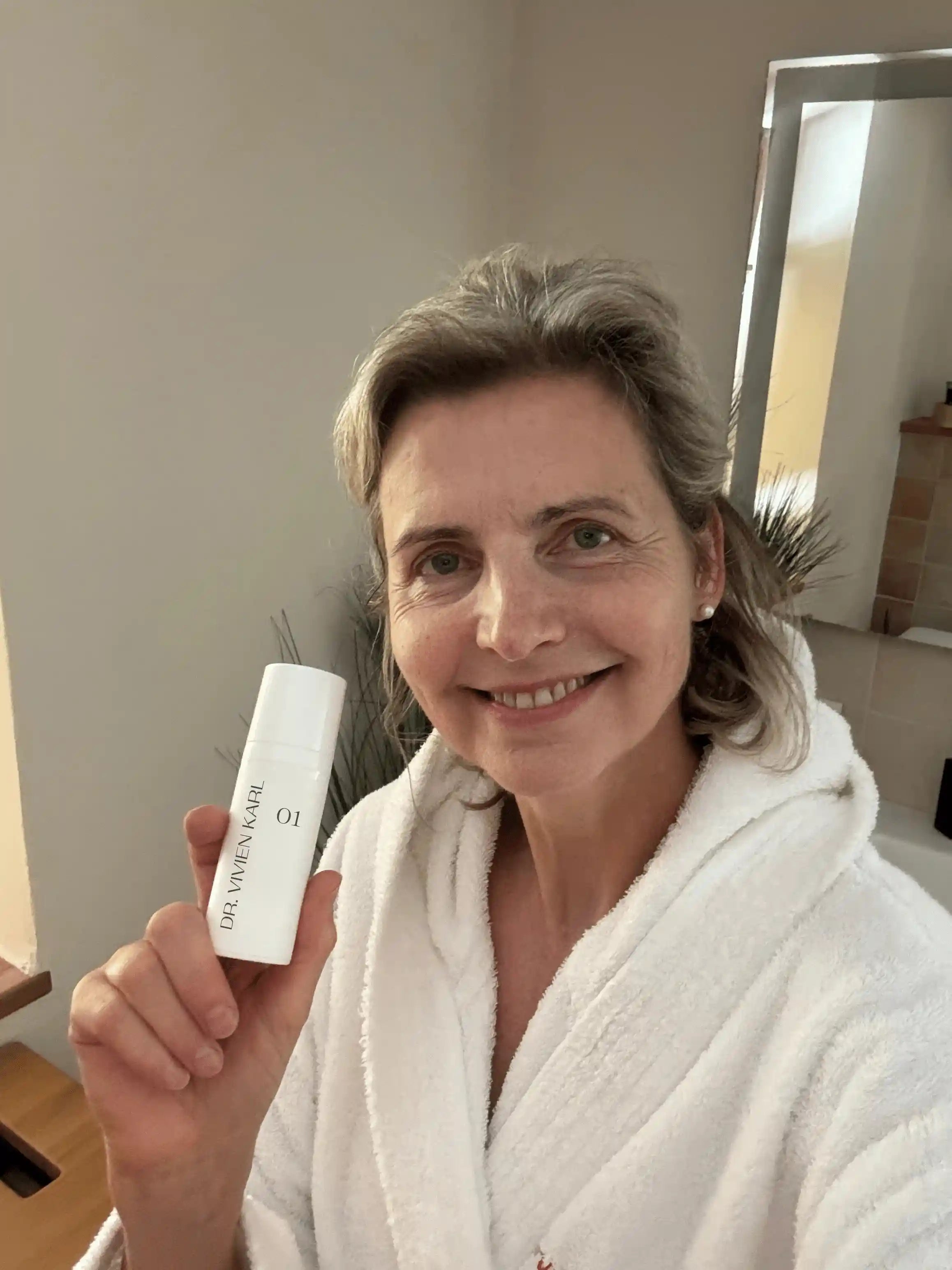 Frau hält Intimcreme 01 in die Kamera