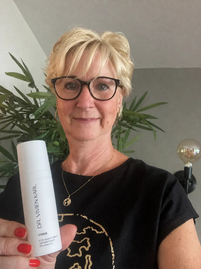 Kundin hält die DR. VIVIEN KARL Intimcreme in die Kamera