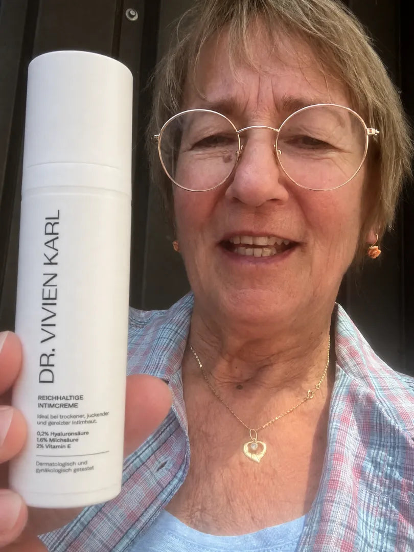 Kundin hält die DR. VIVIEN KARL Intimcreme in die Kamera