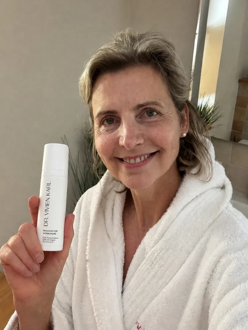 Kundin hält die DR. VIVIEN KARL Intimcreme in die Kamera